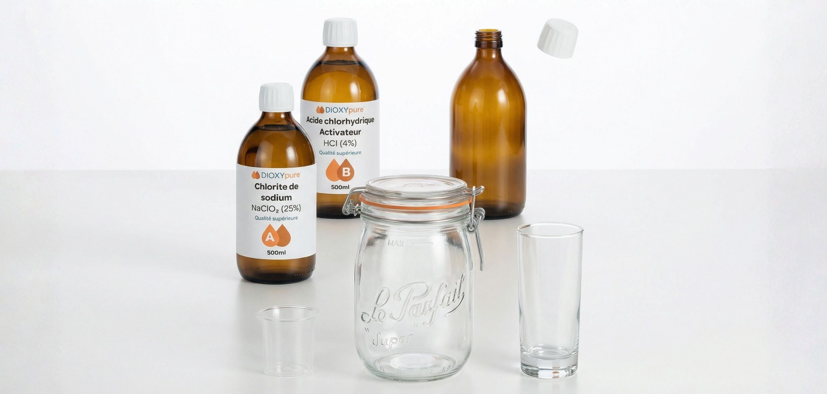 Bouteilles de chlorite de sodium et d’acide chlorhydrique avec bocaux et verres sur table blanche.